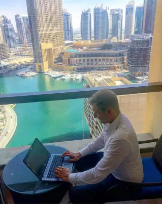 Digital Nomads lifestyle: How do they actually live? : Digital Nomad working from his hotel room in Dubai Marina